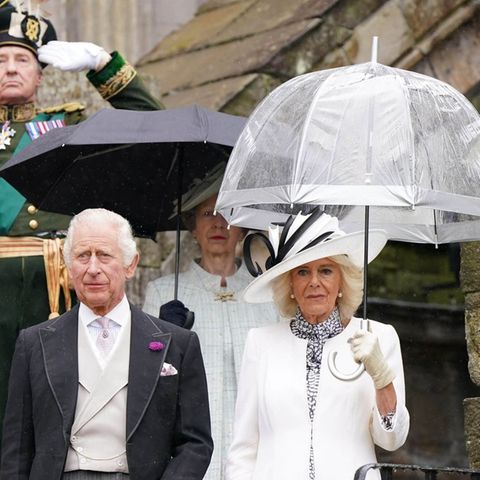 König Charles III. und Königin Camilla während ihrer regnerischen Gartenparty in Edinburgh.
