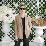 In einer weit geschnittenen Lederhose, derben Boots und einem cremefarbenen Blazer mit doppelter Knopfreihe posiert Cara Delevigne für die Fotograf:innen bevor es für das Model auf die Tribüne geht. 