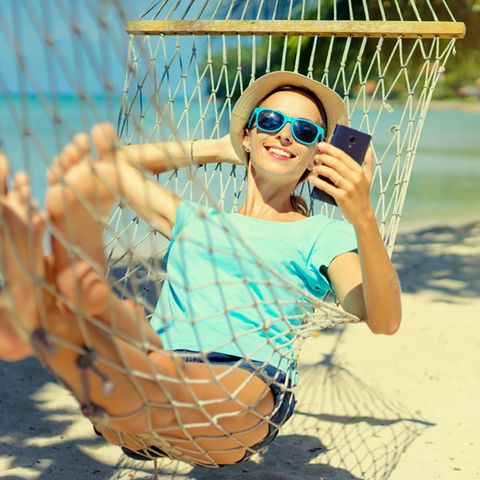 Ein Selfie machen, es für Freunde hochladen, auf Kommentare reagieren, und, und, und: Auch im Urlaub lösen sich viele Deutsche