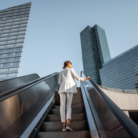 Bill Gates: Eine Frau fährt auf einer Rolltreppe nach oben