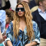 Sängerin Shakira entscheidet sich für einen extravaganten Wimbledon-Look, der auf jeden Fall für Aufsehen sorgt. In einer Jeansjacke im Patchwork-Style, unter der ein Jeans-BH rausschaut, sticht sie eindeutig aus der Menge der Wimbledon-Zuschauer:innen hervor. Die große Sonnenbrille mit knallig-blauem Rahmen ist auch nicht weniger auffällig. 