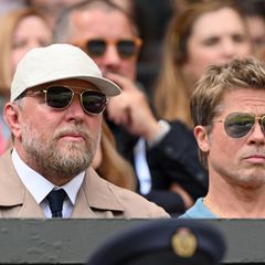 Guy Ritchie und Brad Pitt sitzen gespannt auf der Tribüne – mit Partnerlook-Sonnenbrillen im Piloten-Style lässt sich das Finale noch besser verfolgen. 