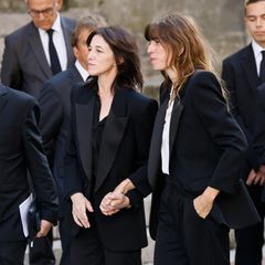 Jane Birkins Töchter Charlotte Gainsbourg und Lou Dillon halten sich vor der Trauerfeier an den Händen. 