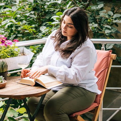 Frau liest auf dem Balkon: Diese 5 Gedanken haben intelligente Menschen täglich