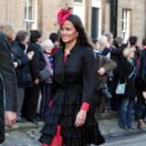 Für die Hochzeit von Lady Katie Percy und Patrick Valentine in der St. Michael's Church in Alnwick, England hat sich Pippa Middleton einen Stilmix ausgesucht: rotes Spitzenkleid unter schwarzem Volant-Mantel, und natürlich das passende Hütchen mit floralem Dekor dazu.