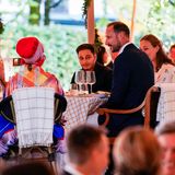 Die Gäste an den Tischen sind bunt gemischt, Haakon sitzt nicht mit seiner Frau zusammen.