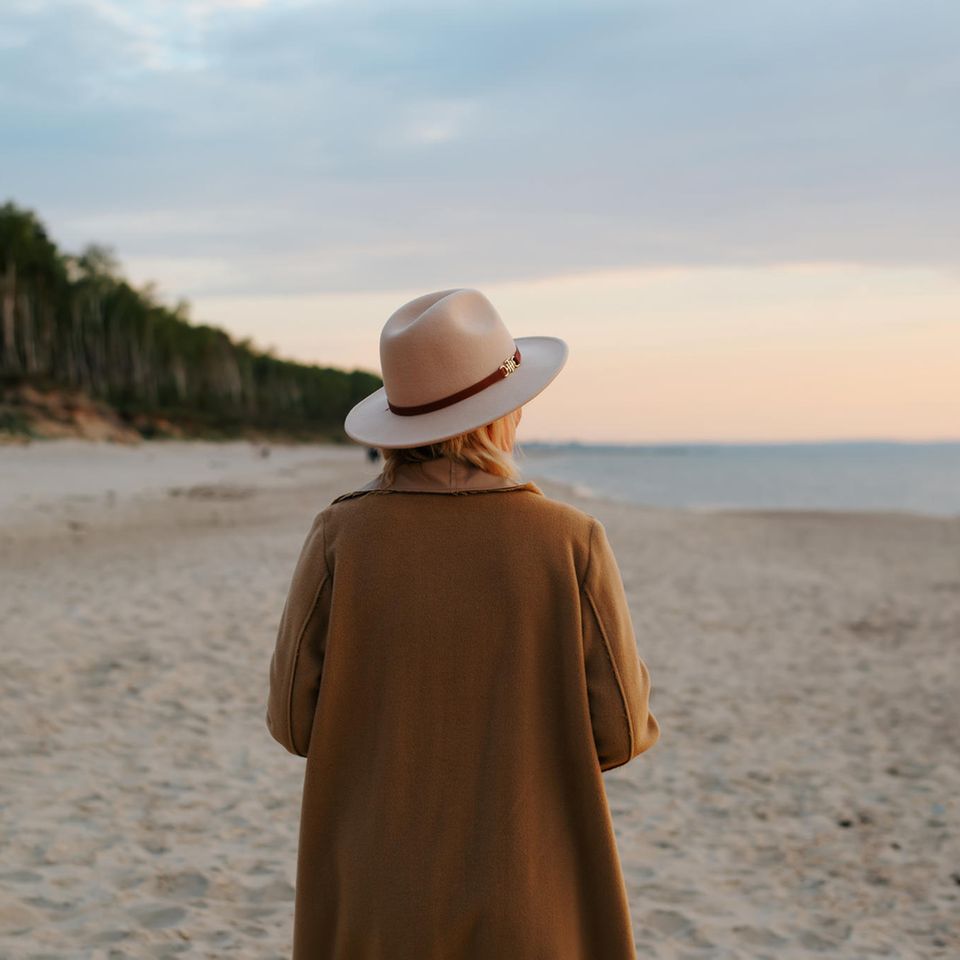 Frau geht allein am Meer spazieren: An diesen Gewohnheiten erkennen Sie Menschen, die gern allein sind
