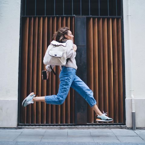 Deal des Tages: Levi's 501 – Kult-Jeans 40% reduziert, Frau mit Jeans und Rucksack macht Freudensprung