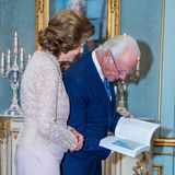 Dieses Präsent scheint die Aufmerksamkeit des Königspaars besonders auf sich zu ziehen. Interessiert schauen Silvia und Carl Gustaf in das Buch.