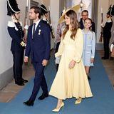 Prinz Carl Philip kommt mit seiner Frau Prinzessin Sofia, die sich für ein zitronengelbes Kleid mit farblich passendem, auffälligem Hut entschieden hat. Hinter ihr grinst Prinzessin Estelle in die Kamera.