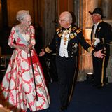 Die dänische Königin Margrethe wird von Schwedens König höchstpersönlich zum Jubiläumsbankett geführt. Für das Event hat die für ihren ausgefallenen Modegeschmack bekannte Königin natürlich auch wieder zu einer besonderen Robe gegriffen.
