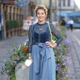 Laura Osswald zeigt sich zu diesem Anlass in Taubenblau. Velour-Top trifft auf florale, transparente Bluse und Streifen-Look. An den Füßen ist Partystimmung angesagt, kombiniert sie Schuhe mit Pailletten zum traditionellen Look. 