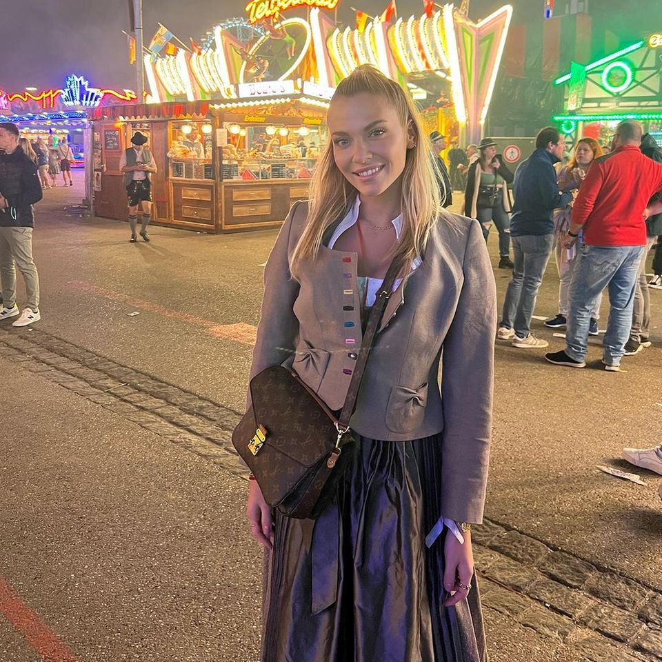 Valentina Pahde feiert – wie sie selbst sagt – ihre erste Wiesn seit fünf Jahren. Mit einer Half-up-Half-Down-Frisur und einer auffälligen Dirndl-Jacke mit farbigen Nähten lächelt die Schauspielerin in die Kamera. Zum Dirndl kombiniert die Schwester von Cheyenne Pahde eine luxuriöse Louis-Vuitton-Tasche: Das Modell Pochette Métis gibt es für ca. 2.100 Euro. 