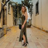 Iris Mareike Steen besucht eine Hochzeit auf Sizilien. Mit ihrem langen khakifarbenen Spaghetti-Träger-Kleid hat sie als Hochzeitsgast ein schmeichelndes Dress ausgewählt. Der lange Beinschlitz umspielt ihre Waden und lässt schwarze Absätze hervorblitzen. Eine schwarze Tasche matcht zum Schuhwerk und rundet ihr Outfit ab.