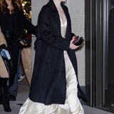Auch Partygast Emma Stone setzt auf monochrome Eleganz. Der schwarze Mantel verhüllt ein cremefarbenes Satinkleid. 