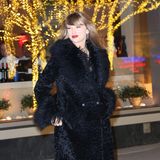 Kuschelig eingepackt zeigt sich Superstar Taylor Swift auf dem Weg zur Aftershowparty der "Poor Things"-Premiere in New York. Unterm Kunstpelz mit Lammfell-Optik trägt sie ein elegantes, schwarzes Kleid, kombiniert mit Peep-Toe-Stilettos. Und mit ihren roten Lippen ist der Party-Look schon beinahe weihnachtlich.