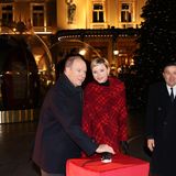 Gemeinsam aktiviert das Fürstenpaar die Weihnachtsbeleuchtung auf dem Place du Casino in Monaco. Passend zum Anlass hat sich Charlène an diesem Abend in einen schicken roten Mantel gehüllt und trägt Lippenstift in Weihnachtsrot.