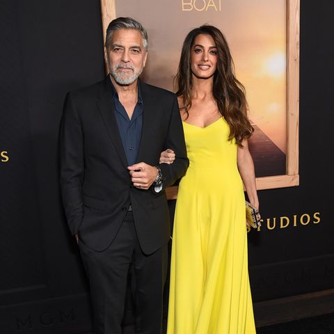 Sorry, Mister Clooney, aber bei diesem Look hatten ganz sicher alle nur Augen Ihre Frau. Amal Clooney zeigt sich bei der L.A.-Premiere von "The Boys In The Boat" an der Seite von Ehemann George und bezaubert im sonnengelben A-Linien-Kleid mit geometrischem Herzausschnitt und punktet damit auf ganzer Linie. Ihre Haare hat die britisch-libanesische Juristin zur sanften Wellen frisieren lassen, bronzy Make-up rundet den sonnengeküssten Look ab. 