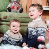Hier kommt Weihnachtsstimmung auf! Im winterlichen Partnerlook sitzen Baby François und Prinz Charles nebeneinander und posieren fröhlich für ein Foto. 