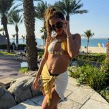 Was für ein schöner Urlaubslook! In Dubai lässt sich Sarah Engels gerade mit ihrer Familie die Sonne auf den Bauch scheinen. Das Strandtuch, welches sie locker um die Hüften geknotet hat, passt dabei perfekt zu ihrem zweifarbigen Bikinioberteil mit goldenen Details. 