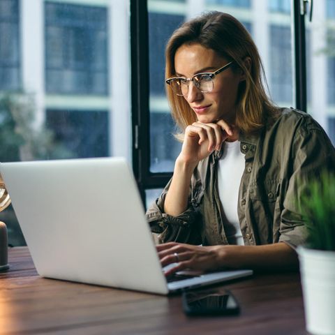Frau arbeitet konzentriert am Laptop: Die wichtigste Strategie für mentale Stärke und Erfolg