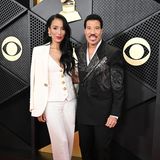 Lionel Richie darf bei den Grammys natürlich nicht fehlen, sein Anzug mit Libellen-Applikation ist dabei ein glitzernder Blickfang. Und auch seine langjährige Freundin Lisa Parigi sieht im cremefarbenen Anzug mit Goldknopf-Weste toll gestylt aus.