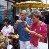 1985  Uschi Glas und Günter Pfitzmann drehen für das "Traumschiff" in Thailand. Zusammen erkunden sie die Stadt und probieren Ananas an einem Straßenstand. 