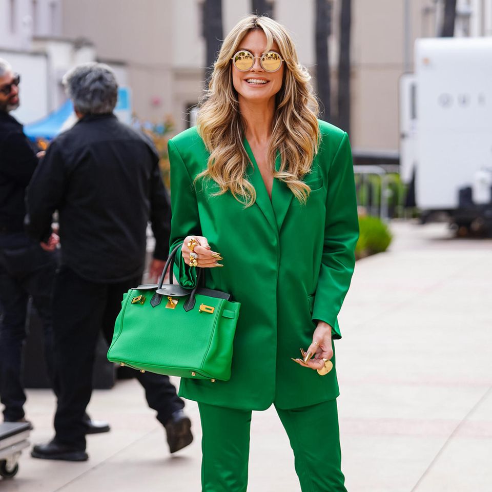 Heidi Klum sieht grün – zumindest in Sachen Styling! Bei den Aufzeichnungen von "America's Got Talent" zeigt sich die Moderatorin im grünen Allover-Look und sieht dabei einfach umwerfend aus. Der glänzende Satinanzug verleiht dem Outfit Glamour, während die goldenen Accessoires einen aufregenden Akzent setzen. Besonderes Highlight ist ihre Hermès-Tasche, die farblich perfekt zum gesamten Look passt.