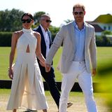 Was für ein schöner Anblick! Herzogin Meghan besucht gemeinsam mit Prinz Harry das "Royal Salute Polo Challenge"-Turnier in Miami und strahlt dabei gut gelaunt mit ihrem Outfit um die Wette. Meghan setzt auf schlichte Eleganz in Weiß mit einem Cut-Out-Kleid mit Neckholder-Detail von Heidi Merrick. Schlichte spitze Pumps von Aquazzura, eine XL-Sonnenbrille von Heidi Merrick und Vintage-Ohrringe von Chanel komplettieren den Look perfekt, ohne abzulenken.