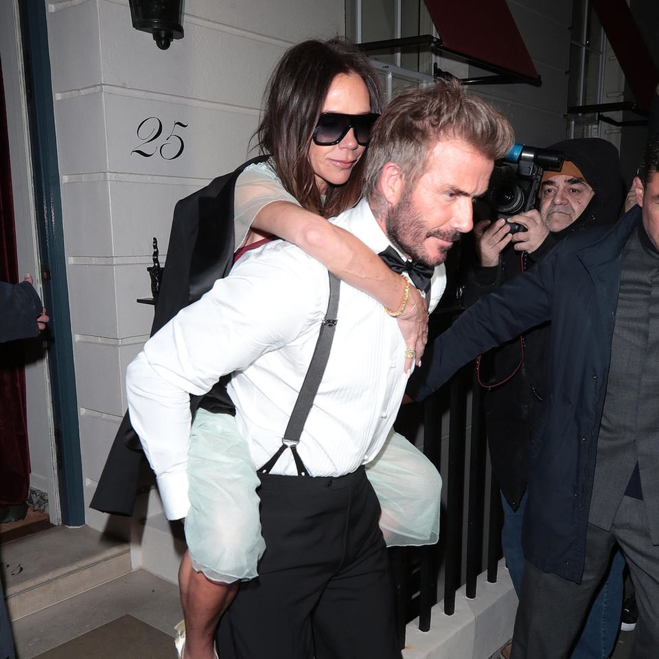 David Beckham trägt Geburtstagskind Victoria Huckepack aus dem Privatclub "Oswald's" in London.