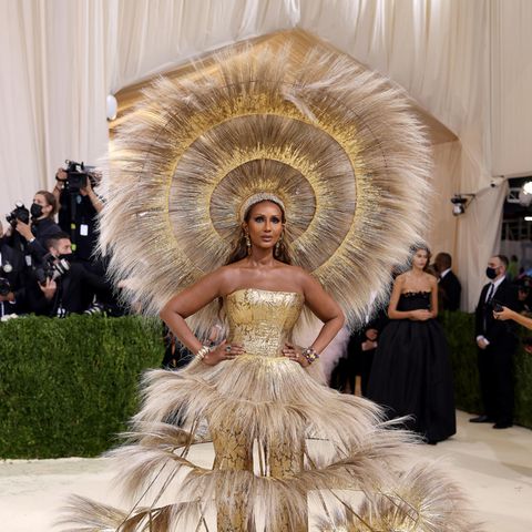 Supermodel Iman legt mit dem sonnig-goldenen Feder-Dress von Dolce & Gabbana in Zusammenarbeit mit Harris Reed einen der tollsten Met-Gala-Auftritte hin.
