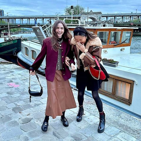 Was gibt's denn hier zu lachen? Die "Emily in Paris"-Stars Lily Collins und Ashley Park sind die ersten, die zur Abschlussfeier der Dreharbeiten für die vierte Staffel zum Party-Boot am Port de Suffren an der Seine gekommen sind. Und damit können die beiden Schauspielerinnen auch als erste die Tanzfläche erobern.