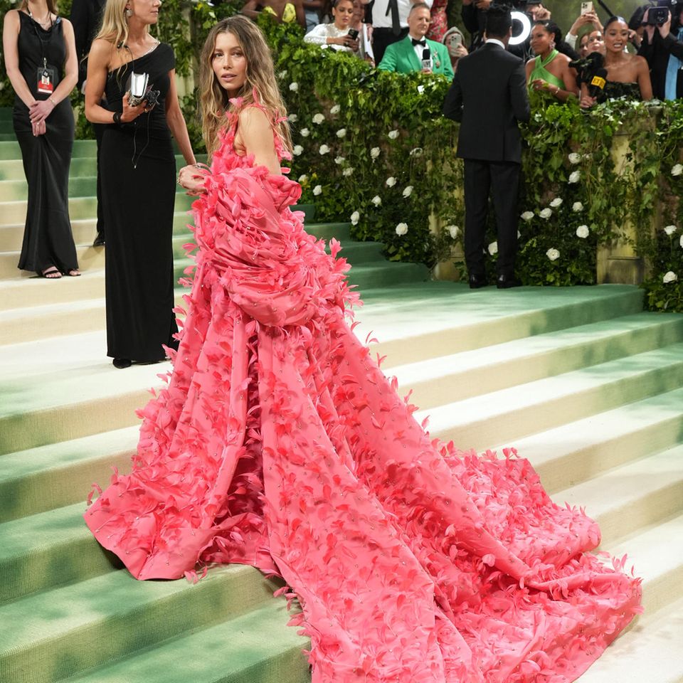 Jessica Biel begeistert in einem atemberaubenden, leuchtend rosafarbenen Kleid von Tamara Ralph, das mit Tausenden von dreidimensionalen Blütenblättern verziert ist. Eine lange Schleppe sorgt für einen zusätzlichen glamourösen Aufmacher. 