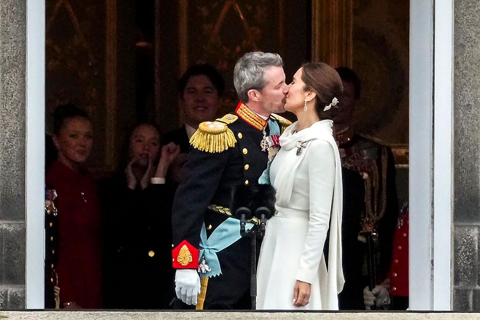 König Frederik und Königin Mary küssen sich kurz nach der Proklamation – und ihre Kinder jubeln im Hintergrund.