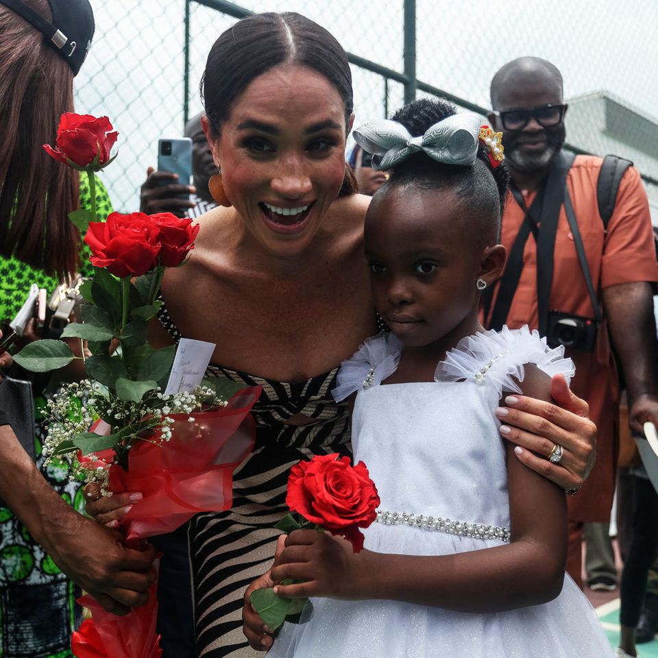 Bei Nigeria Unconquered werden sie von allen mit Blumen und Freude begrüßt. Und ein wenig Schüchternheit, die Herzogin Meghan mit ihrer Herzlichkeit überspielt.