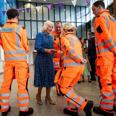 9. Mai 2024 Am International Nurse Day besucht Königin Camilla das medizinische Team der Air Ambulance im Royal London Hospital, und wird dort von einer Sanitäterin mit perfektem Knicks begrüßt. Das sieht mit der knalligen Warnschutzbekleidung ziemlich witzig aus und erheitert auch die Königin sichtlich.