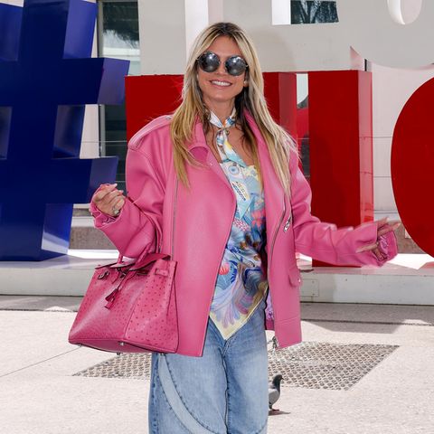 Barbie oder Ken? Heidi Klum kombiniert einfach beide Looks miteinander: XL-Lederjacke in Pink, passende Birkin-Bag, dazu ein wild gemustertes Seidentop mit passender Krawatte, und weite Patchwork-Jeans. So macht sie bei ihrer Ankunft in Nizza gleich mächtig Eindruck.