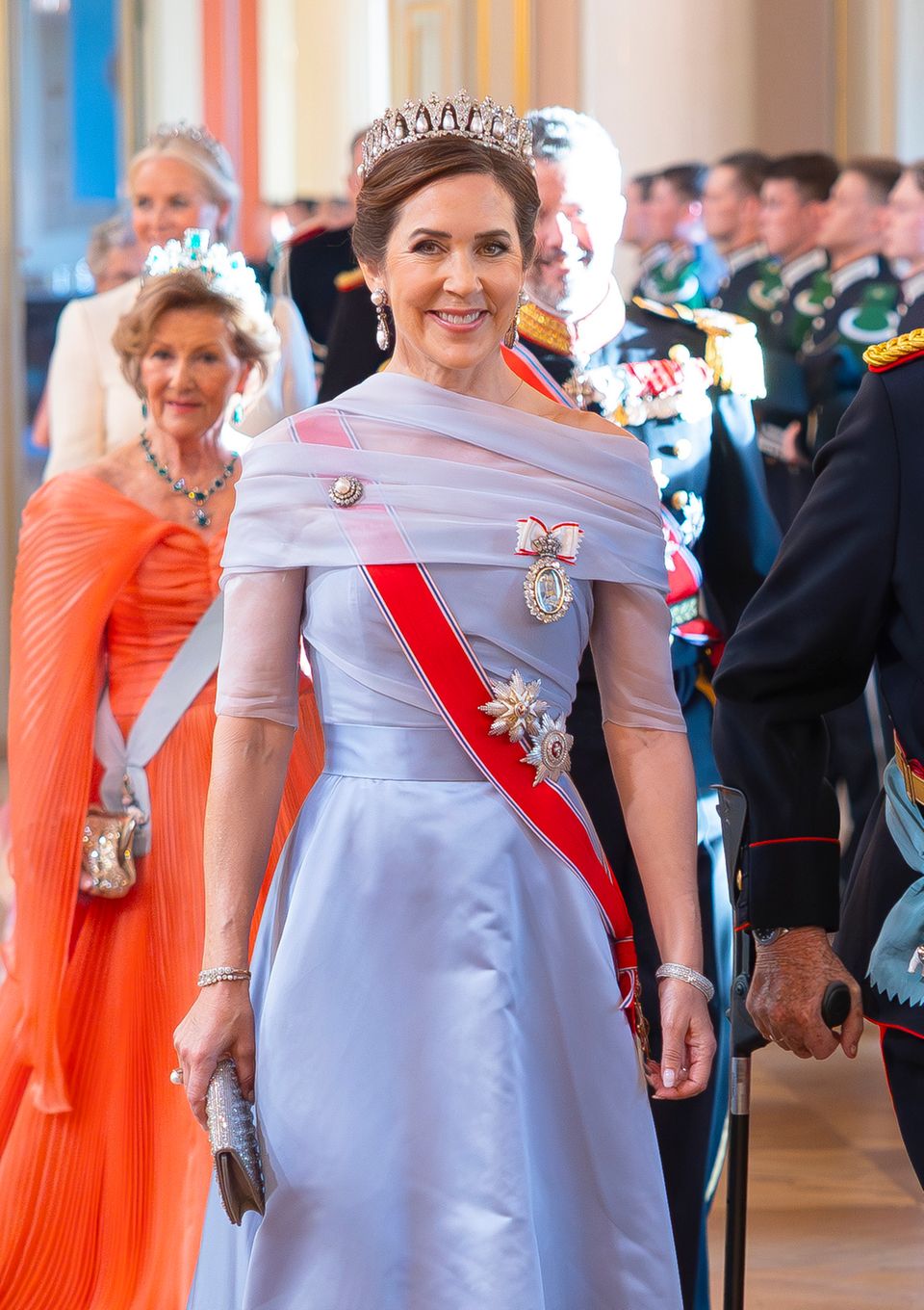 Königin Mary lächelt ihre kleinen Falten am Kleid gekonnt weg.