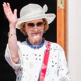 Auch Königin Sonja setzt bei dem schönen Wetter auf Sonnenbrille und Hut. Vom Balkon aus schaut sie sich die Feiertagsparade an und winkt der Menge zu.