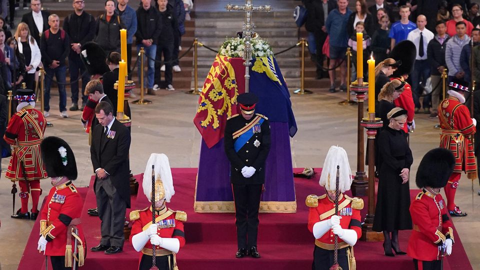 Prinz William (vorne Mitte), Zara Tindall (rechts daneben), Lady Louise (dahinter), Prinzessin Beatrice (hintere Ecke rechts), Prinz Harry (hinter dem Sarg), Prinzessin Eugenie (hintere Ecke links), James, Earl of Wessex (links Mitte), und Peter Phillips (vordere Ecke links) am 17. September 2022 bei der Mahnwache zu Ehren von Queen Elizabeth in der Westminster Hall in London