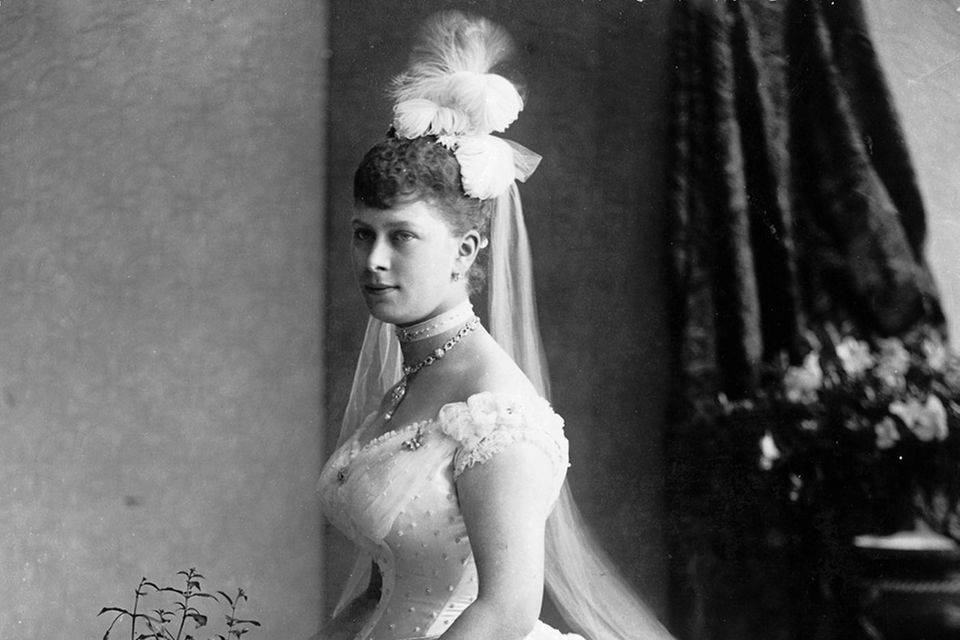 Queen Mary von England, wie sie eine Feder mit einer Aigrette befestigt.